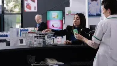 pharmacy-buyer-giving-cashier-medications-for-scan-utc